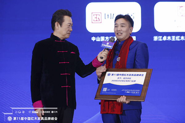 国方家居董事长陈新平（右一）接受央视知名主持人赵保乐（左一）台上采访，分享国方家居红木工艺整装特色