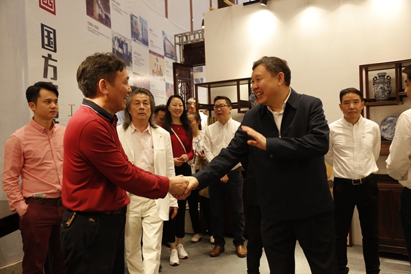中山红博会预展期间，中国家具协会理事长徐祥楠（右二）等领导一行参观国方家居展位，领略中式原木整装魅力
