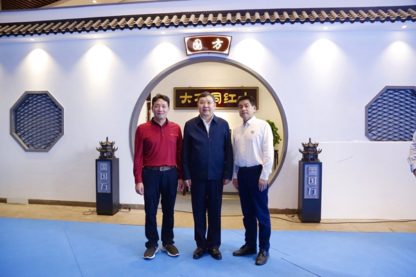 中国家具协会理事长徐祥楠（中）、中山市大涌镇镇长贺修虎（右一）与国方家居董事长陈新平在国方家居展位前合影留念
