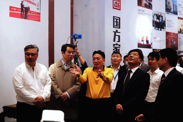 中国林业产业联合会副会长兼秘书长王满、副会长蒋周明，中山市人大常委会副主任吴军，中山市政协副主席刘志伟，中山市大涌镇党委书记王英康、镇长贺修虎，东阳市副市长黄阳明等领导一同参观国方家居展位，国方家居董事长陈新平为领导专家介绍国方家居中式原木整装整装工艺