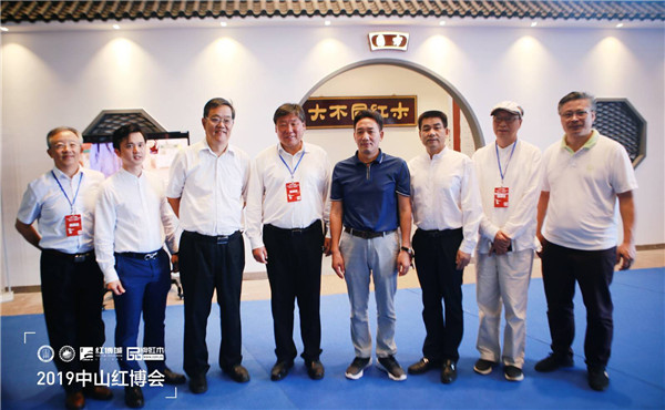 国方家居董事长陈新平（右四）与领导、专家在国方家居展馆合影留念。（右一 中山市红木家具行业协会会长 林志洪；右二 教育部教学改革示范专业“家具设计与制造”专业带头人彭亮；右三 中山市大涌镇镇长贺修虎；左一 华南农业大学博士生导师李凯夫；左二 全联艺术红木家具专业委员会执行会长、弘木传媒CEO林伟华；左三 国家林业和草原局森林资源管理司原副司长、国有林场GEF国家项目执行办公室技术顾问张松丹；左四 中国林业产业联合会副会长、北京林业大学原校长宋维明）