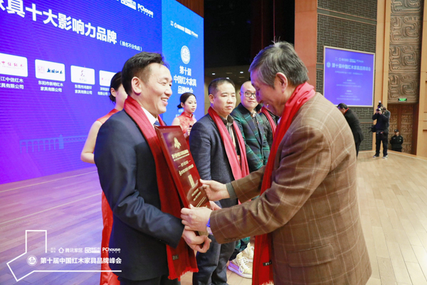 故宫博物院文保科技部原主任曹静楼（右一）为国方家居（左一）颁发“2019红木家具十大影响力品牌”牌匾
